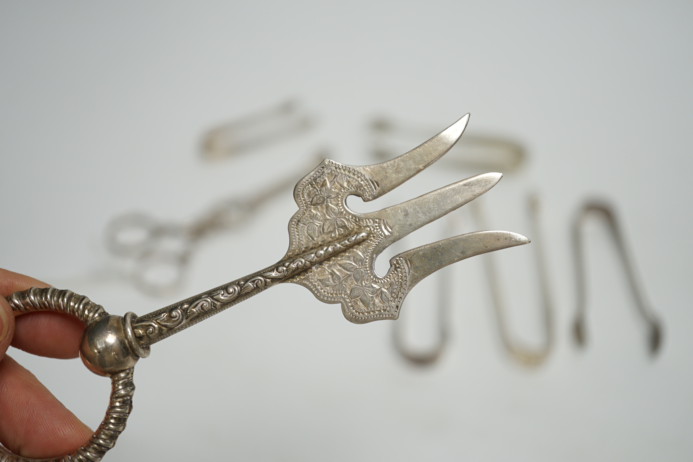 A pair of 18th century Irish silver sugar nips, together with sixteen later mainly 20th century silver sugar nips, various dates and makers, eight plated pairs and a small silver toasting? fork.